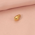 Polished golden water drop pendant in titanium steel on soft pink fabric background - Gold Water Drop Pendant
