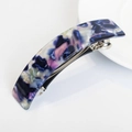 Detailed macro of large marble acetate spring hair clip with blue and purple stone patterns - Colorful