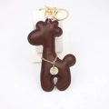 Brown PU leather giraffe keychain with gold metal ring and decorative charm on white background - Brown