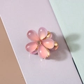 Close-up of a pink resin flower hair claw with a gold metal base and rhinestone - Resin Cat Eye Style / Pink