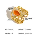 Detailopname van een geweven roestvrijstalen ring met een oranje opaal inleg - Verstelbaar Open / Goud (Met oranje steen)