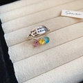 Primer plano de un anillo ovalado plateado con grabado en latín y tres dijes de circón - Colgante Tricolor Plata Grabado (35#)