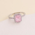 Elegante anillo de plata con circón rosa talla esmeralda y halo sobre fondo neutro - US 6 / Plateado