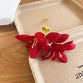 Détail d'épingle à cheveux fleur en tissu rouge avec base dorée sur support papier - Rouge