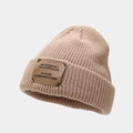 Detail of beige knit beanie showing vertical ribbed texture and brown leather patch - Khaki