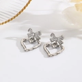 Gros plan de boucles d'oreilles nœuds argentées avec zircons et pendentifs en forme de cœur - Argent (ZYN-DME240602P)