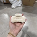 Hand holding a plush square claw clip in cream white soft faux fur for women - Medium Beige (approx. 10cm)