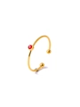 Detailed macro view of a gold open ring featuring a round red gemstone and ball accents - Red