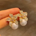 Funkelnde Lilien Ohrstecker mit Vergoldung, Zirkonia und weißen Perlen besetzt - E1290-Gold Perle Lilienblüte