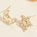 Detailed macro view of asymmetric 14K gold plated earrings with moon, stars and pearls - Star Moon Earrings / Gold