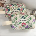 Detail of floral quilted makeup bag with woven handle and vintage brand label - Wristlet / Nostalgic Flower Wrist Bag [Flowering Shrub]