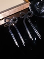 Sparkling black bow tassel earrings with micro-set crystals on a black reflective surface - Stud Earrings / Black and White Gradient