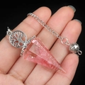 Pink resin tree of life pendulum with crystal chips and silver chain held in hand - Rose Quartz