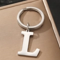 Polished silver metal letter L keychain with circular ring on a brown gift box - L