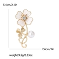 Elegante broche de trébol dorado con flor blanca, perla y dimensiones detalladas de talla - Dorado