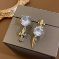 Boucles d'oreilles asymétriques plaquées or avec pierres claires, croix et iris - Croix asymétrique et iris dorés