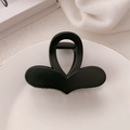 Dettaglio di una pinza per capelli a farfalla nero opaco su un piatto bianco raffinato - Satinato / Cuore Nero Opaco