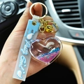 Creative heart-shaped liquid quicksand keychain with blue silicone strap and golden bell - Colorful