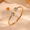 Nahaufnahme eines minimalistischen goldenen Titanstahl-Armreifs mit zwei Strasssteinen. - Doppel-Strass-Offen-Design (F713) / Gold