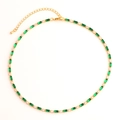 Detail of gold necklace with green rectangular stones and clear round gems on white - Green Necklace