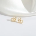 Elegante goldene Herzohrstecker mit glänzenden Zirkoniasteinen auf weißem Satin - Herz / Gold