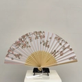 Folding fan with cherry blossom and butterfly print featuring a long white tassel - West Garden Peach