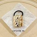 Golden wavy geometric hair cuff accessory with black elastic band on stone base - Liquid