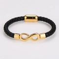 Detalle de pulsera de cuero trenzado negro con símbolo de infinito dorado y cierre imán - Dorado