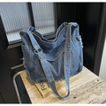 Detail der blauen Denim-Umhängetasche mit ausgefransten Kanten und Metallschnalle - Hellblau