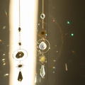 Golden sun catcher pendants with faceted crystals and sun charms reflecting rainbows - Design No.13