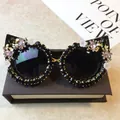 Cat eye sunglasses in black featuring floral crystal embellishments and pink gems - Black Frame / Black Rhinestone