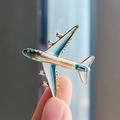 Broche de avión en esmalte blanco perla con detalles azules y bordes dorados finos - Azul
