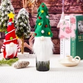 Close-up of festive Christmas tree and gnome wine bottle covers in a cozy setting - Christmas Tree