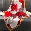 Vintage red and white floral silk scarf with gold border draped on a leather couch - Style 17