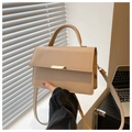 Detalle de bolso en cuero sintético beige con elegante cierre de barra dorada y asa - Caqui