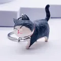 Close-up of cute black and white cat keychain with red collar and bow on white background - Grey/White