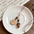 Artistic detail of vintage wax cord necklace with wooden acorn pendant on ceramic dish - Wood Slice Board Style (17#) / Brown