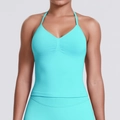 Close-up van heldere cyaan halter yoga beha met gerimpeld midden en stretchstof - XS / Muntgroen