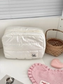 Vista dettagliata della borsa cosmetica trapuntata bianca con cerniera ed etichetta Soda - Bianco