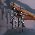 Gothic punk skeleton drop earrings in gunmetal finish hanging on dry wooden branches - Black