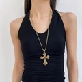 Goldene Punk-Kreuzhalskette mit orangen Edelsteinen an Model mit Neckholder-Top - Goldene lange Kreuzhalskette (X4580)
