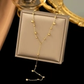 Elegant 18K gold-plated Y-shaped beaded tassel necklace displayed on a gray jewelry box - Y-Shaped Necklace / Gold