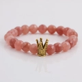 Makroansicht der 8mm rosa Erdbeerkristall-Perlenkette mit goldenem Kronen-Anhänger - Erdbeerquarz