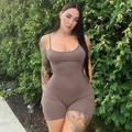 Detail of brown backless bodycon romper with straps and pleated texture in outdoor setting - Nude