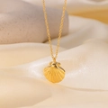 Détail macro du pendentif coquillage en or 18 carats sur un fond élégant en soie crème - Collier Coquillage (QYH340) / Or