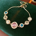 Vista macro de pulsera de oro rosa con cristales coloridos cuadrados y redondos - Morado