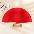 Minimalist red solid wood folding fan on a wooden stand with elegant floral accents - Red