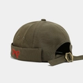 Detailed close-up of olive green docker hat featuring red bow embroidery and metal buckle - Army Green