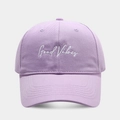 Close-up of Good Vibes white script embroidery on light purple cotton baseball cap - Adjustable / Light Purple