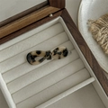 Detailed close-up of a leopard print acetate bow hair claw clip in a wooden jewelry box - Bowknot Snap Clip